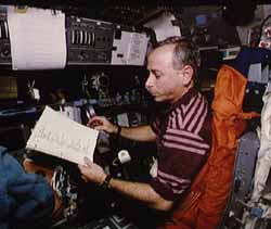 Carl reading checklists on the flight deck. Click here for a NASA site with more pictures from this mission.